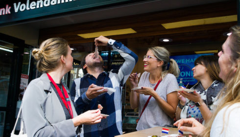 Tourteilnehmer der Amsterdamliebe kulturellen Essenstour essen beim Fischhandel Jonk Hering