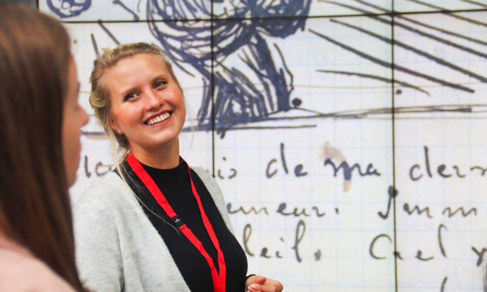 Tourguide von Amsterdamliebe steht vor einer Van Gogh Zeichnung