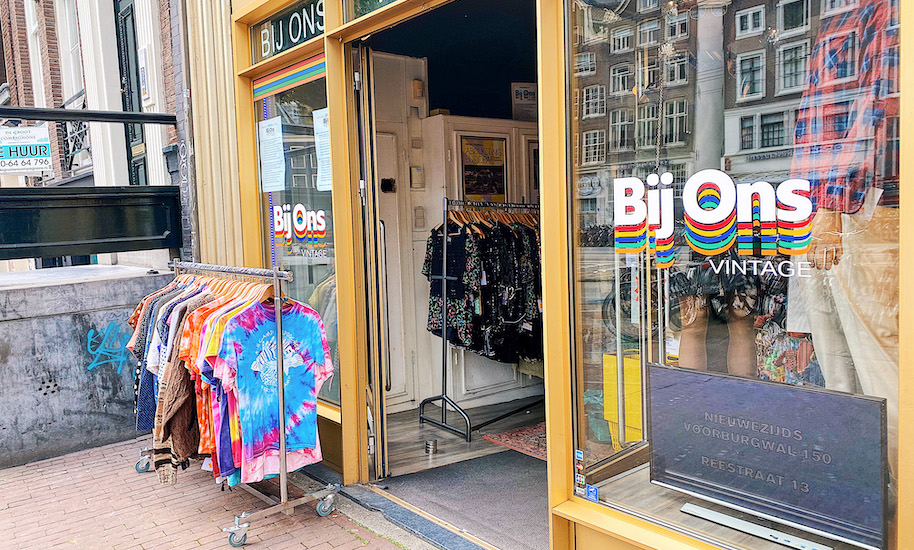 Eingang vom Bij Ons Vintage Laden Amsterdam mit bunten T-Shirts
