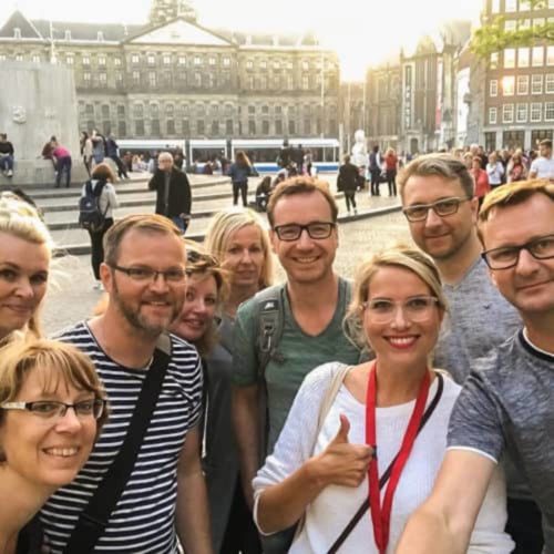 Theresa von Amsterdamliebe mit Tourteilnehmern auf dem Damplatz in Amsterdam