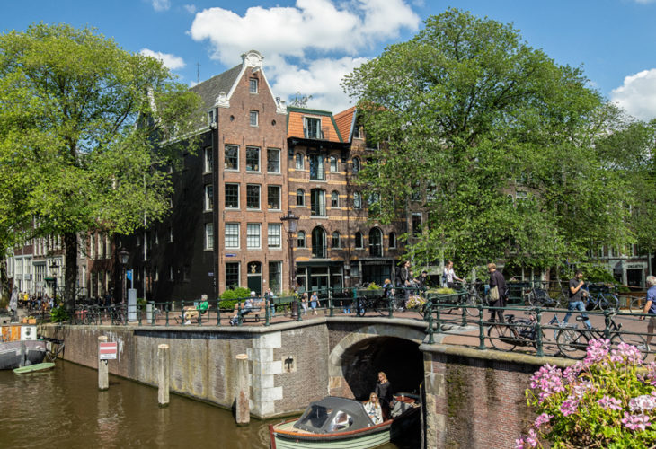 Grachtenboot fährt durch Amsterdamer Grachten