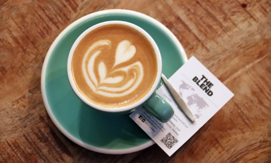 Schön verzierter Kaffee in mint grüner Tasse