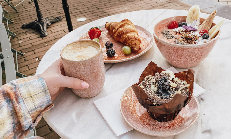 Leckeres Frühstück mit Kaffee, Muffin, Croissant und Fruchtbowl von Pluk