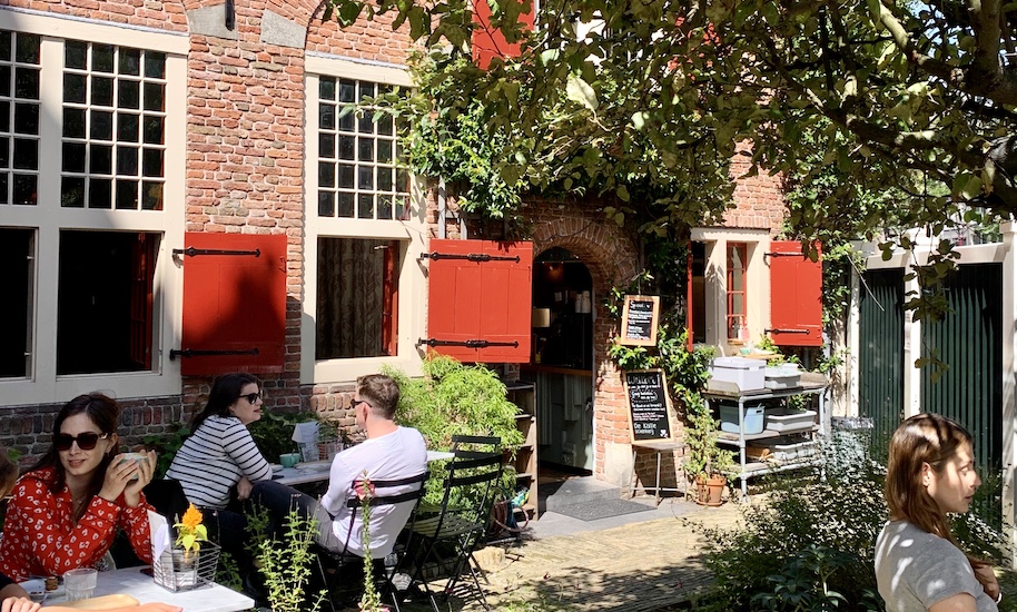 Menschen trinken Kaffee auf der Terrasse von Koffieschenkerij