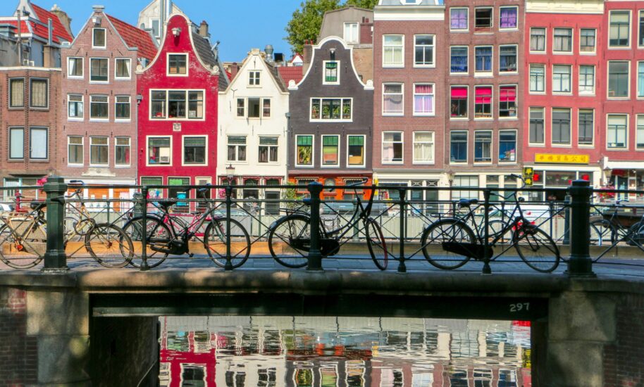 Colourful Amsterdam houses with bicycles on a bridge. Amsterdam city centre scene.
