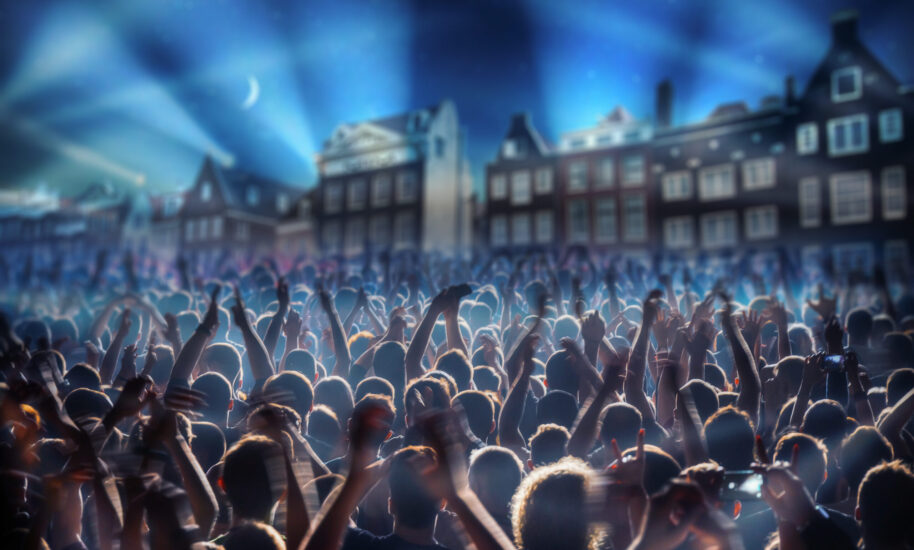 A lively crowd cheering at a concert. People enjoying live music.