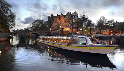 A boat on a canal in Amsterdam. Evening city trip.