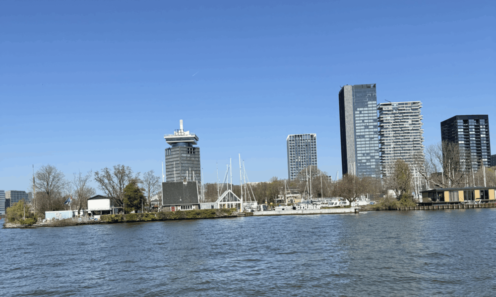Amsterdam city skyline. Water and buildings in the dark.