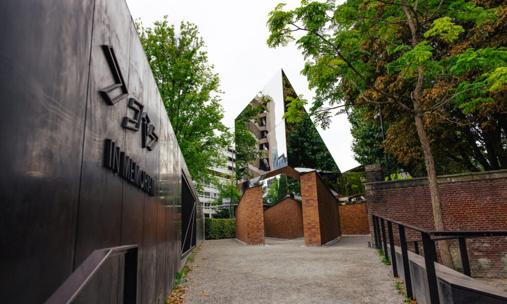 The entrance to the Jewish Cultural Quarter in Amsterdam with a large stone wall on the left.