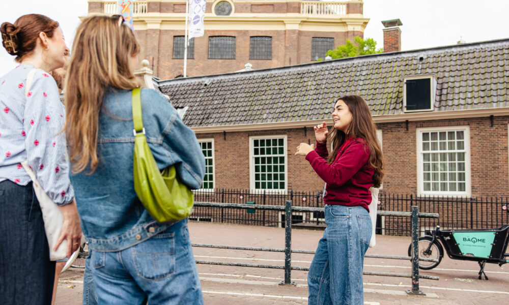 Three young women exploring a city. A woman taking a photo.