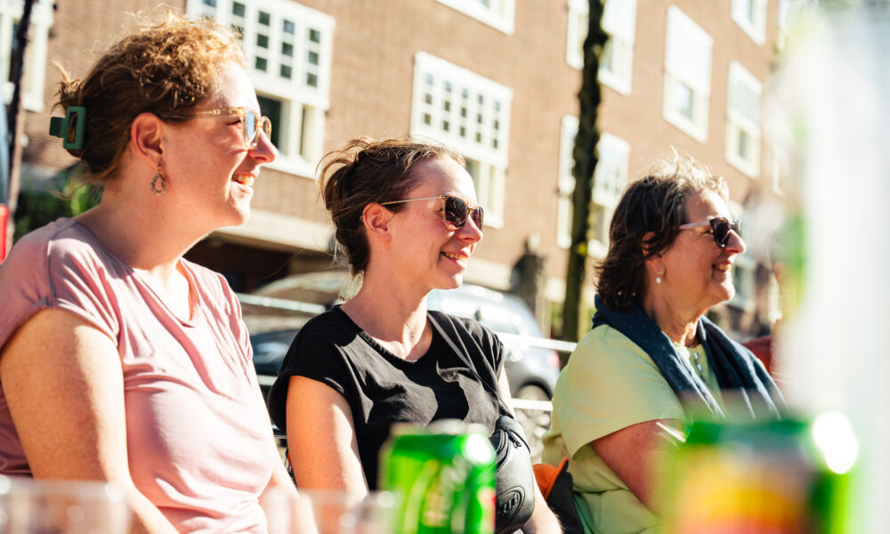 Three women laughing together outside.