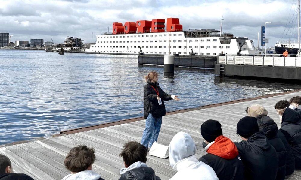 Guided tour on Amsterdam waterfront. A guide talking to tourists