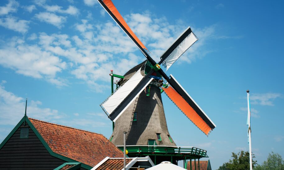 A traditional Dutch windmill with orange blades. The windmill is a classic symbol of Amsterdam.