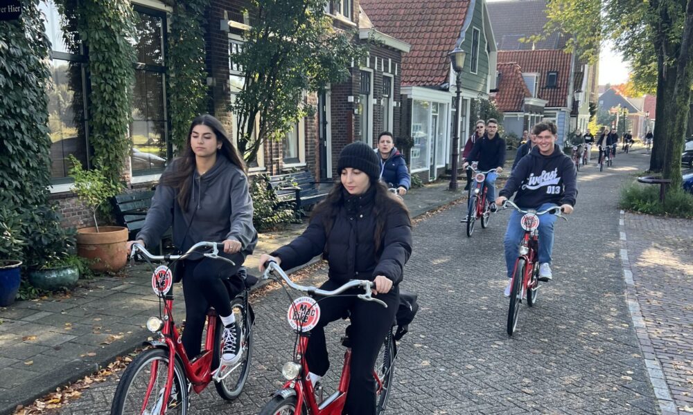 Two women on bicycles exploring Amsterdam. A city best explored by bike.