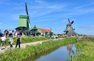 Traditional Dutch windmills and people walking. A serene Dutch scene with windmills at Zaanse Schans