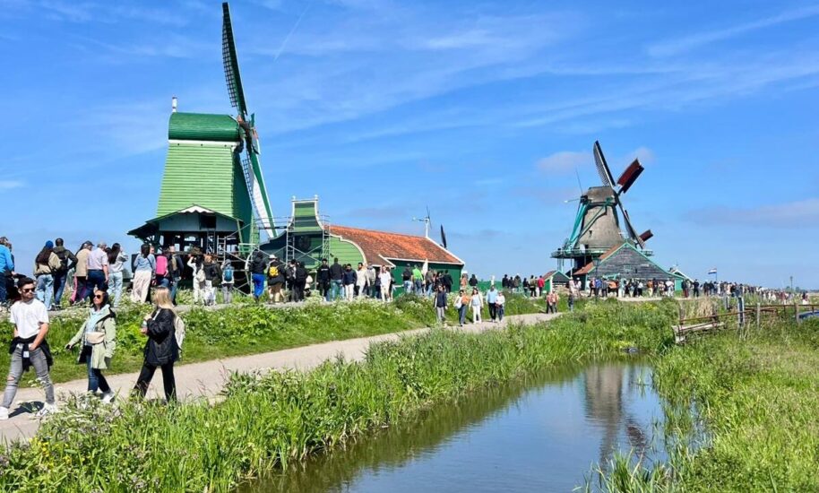 Traditional Dutch windmills and people walking. A serene Dutch scene with windmills at Zaanse Schans