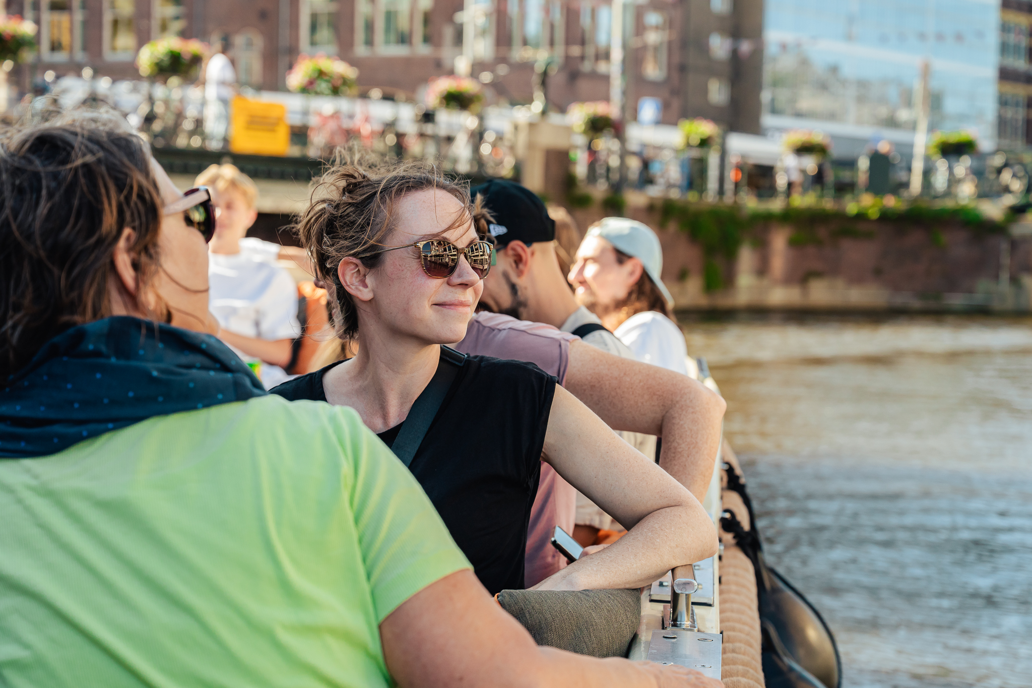 Tourists on a boat trip in Amsterdam. A woman smiling on a boat tour.