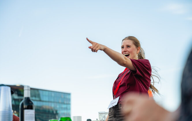 A tour guide from Amsterdamliebe is pointing out a the city on a boat tour.