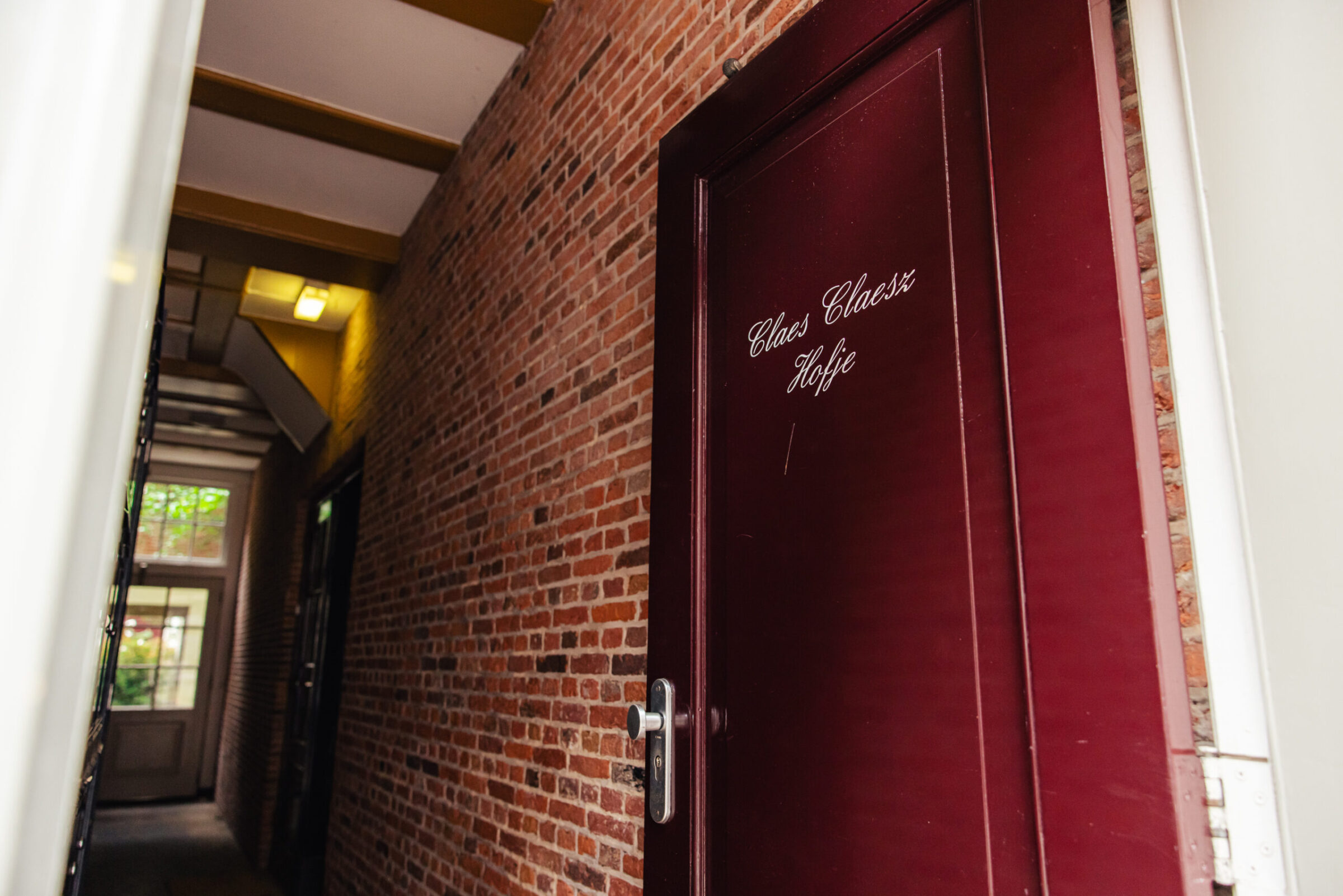 A red door showing the entrance to the Claes Claesz court yard in Amsterdam