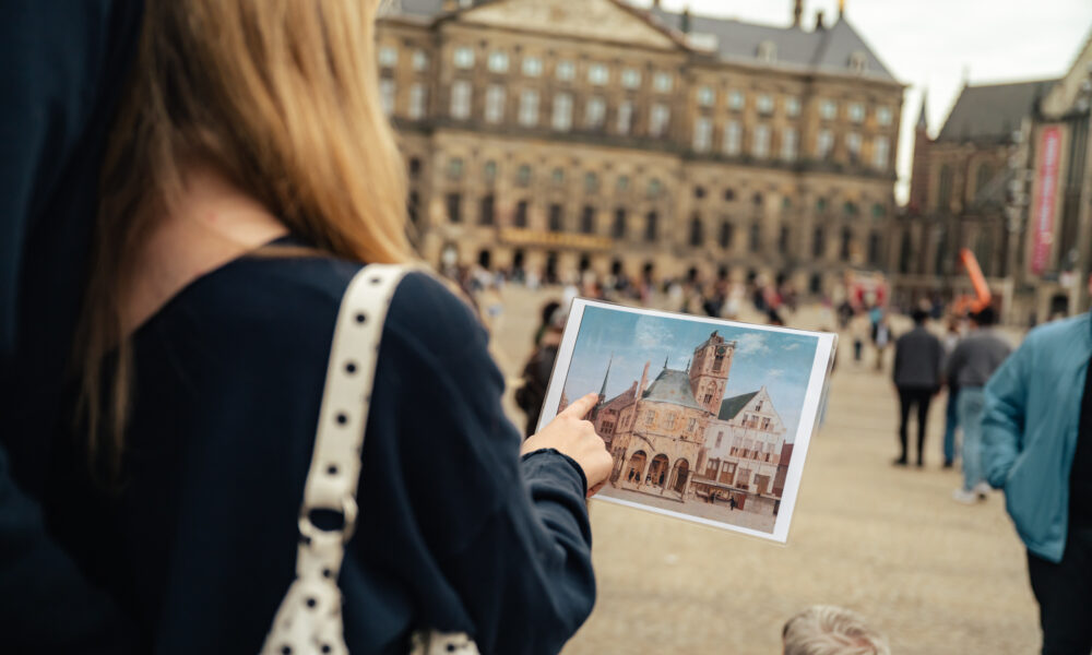 Tourist holding image of famous Amsterdam landmark. The Rijksmuseum.