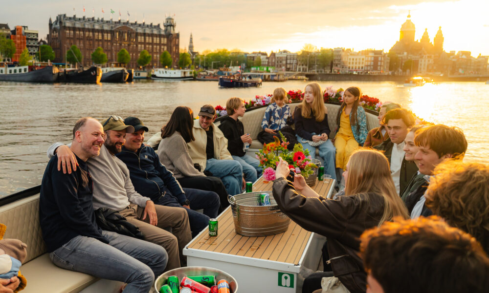 People on a boat enjoying a sunny day in Amsterdam. A group of tourists on a boat tour.